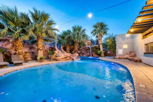 Swimming pool with a water slide and a patio area