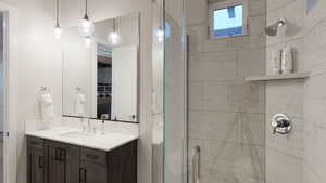 Full bath with a stall shower, vanity, and backsplash