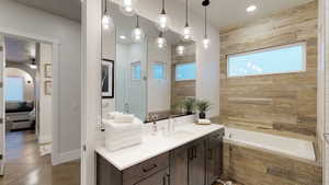 Full bathroom with vanity, a relaxing tiled tub, a tile shower, ceiling fan, and recessed lighting