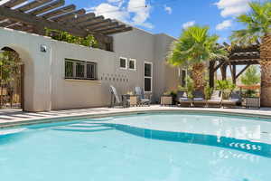 Outdoor pool with a pergola and a patio
