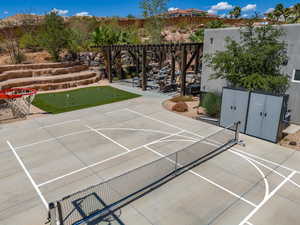 View of sport court featuring a patio area and a pergola