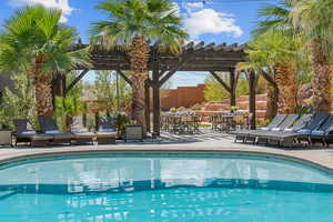 Swimming pool featuring a pergola and a patio area