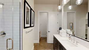 Full bathroom with vanity, a shower stall, and dark tile patterned floors