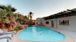Pool at dusk with an outdoor pool, a patio area, and a pergola