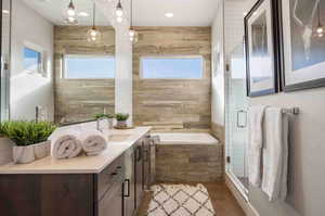 Bathroom featuring vanity, a garden tub, healthy amount of natural light, and a stall shower