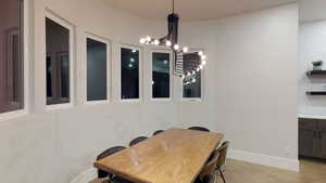Dining space featuring a chandelier and baseboards