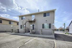 Rear view of property featuring stairway and a fenced front yard