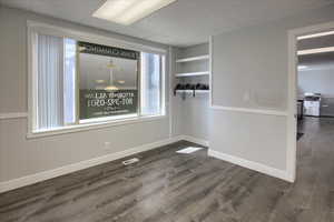 Spare room with dark wood finished floors, wainscoting, and a paneled ceiling