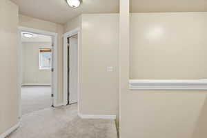 Hall with carpet and baseboards