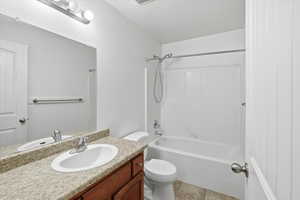 Bathroom with vanity, bathing tub / shower combination, and light tile patterned flooring