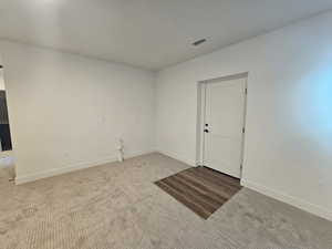 Spare room featuring carpet floors and baseboards