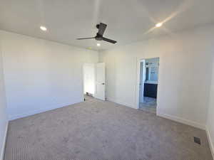 Unfurnished bedroom featuring carpet floors, a ceiling fan, recessed lighting, and ensuite bathroom