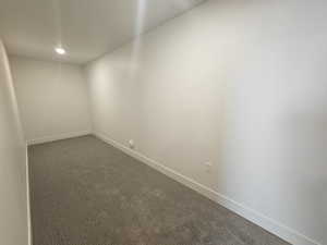 Empty room featuring dark carpet and recessed lighting