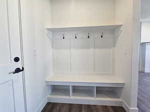 Mudroom featuring dark wood-style flooring and baseboards