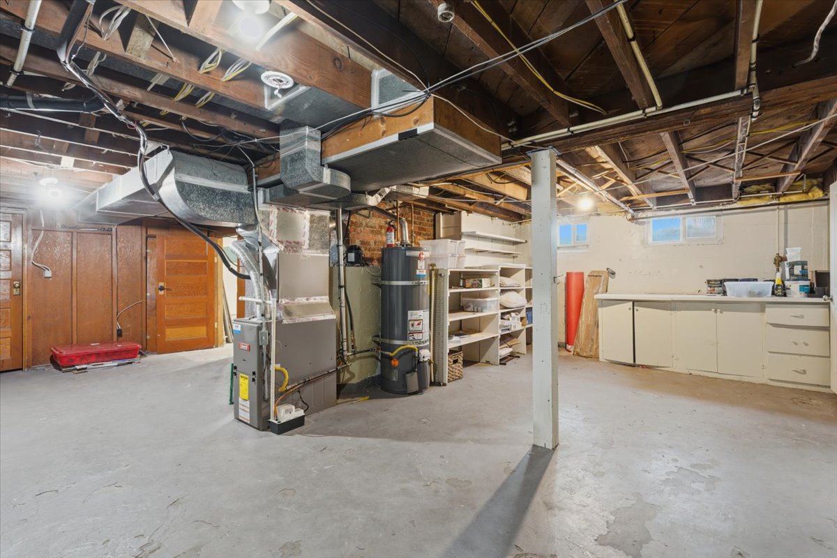 Below grade area featuring strapped water heater and heating unit