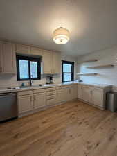 Kitchen featuring light countertops, a textured ceiling, dishwasher, and decorative backsplash