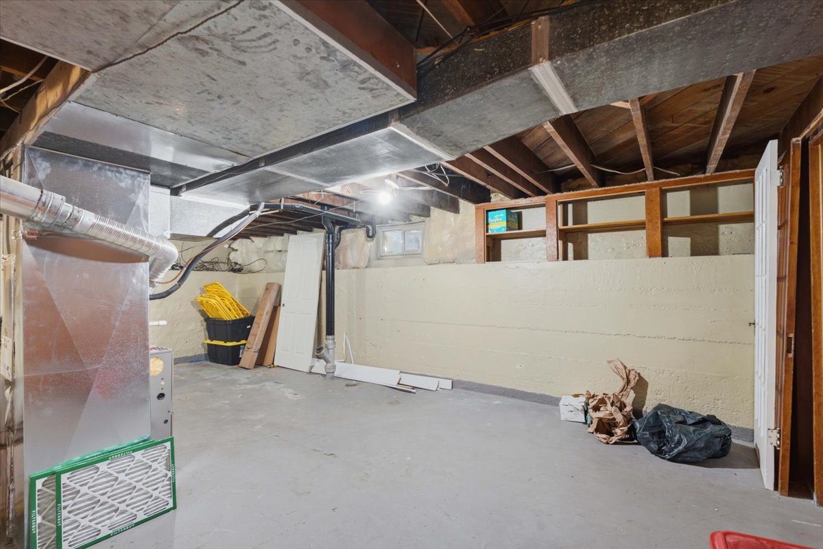 Unfinished below grade area featuring heating unit