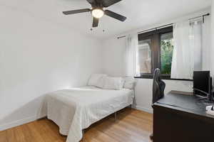 Bedroom featuring an office area, ceiling fan, and light wood-style floors