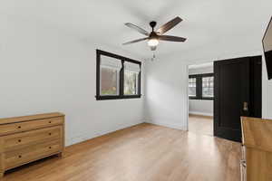 Unfurnished bedroom with ceiling fan and light wood finished floors