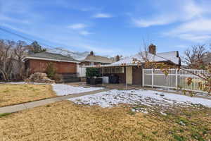 View of snow covered exterior with a chimney and a patio area