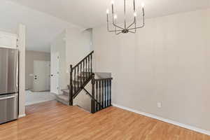 Dining area featuring a chandelier, stairway, and light wood finished floors