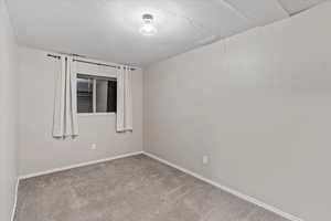 Unfurnished room with a textured ceiling and carpet floors