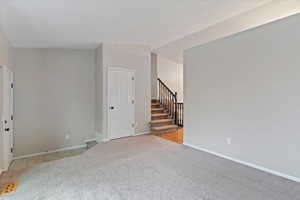 Front room featuring light colored carpet and stairs