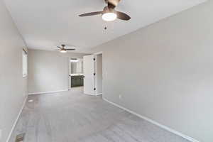 Master room with light colored carpet and ceiling fan