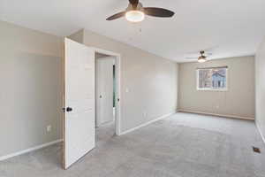 Master room featuring light colored carpet and a ceiling fan