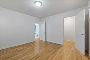 Unfurnished bedroom featuring light wood finished floors and baseboards