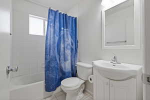 Full bath with tile patterned flooring, vanity, and shower / tub combo with curtain