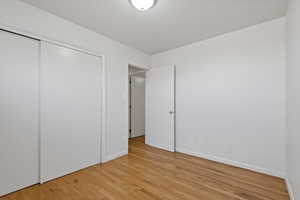 Unfurnished bedroom featuring a closet and light wood-type flooring