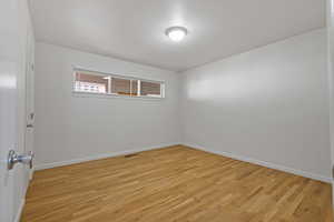Empty room with light wood-type flooring and baseboards