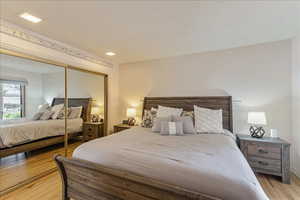 Bedroom featuring a closet, light wood-type flooring, and a textured ceiling
