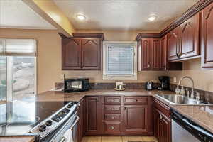 Kitchen featuring appliances with stainless steel finishes, a textured ceiling, dark brown cabinetry, and recessed lighting