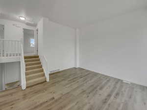 Empty room featuring light wood-type flooring and stairway