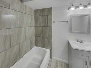 Bathroom featuring vanity and washtub / shower combination