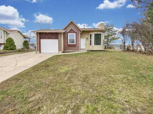 Ranch-style house featuring concrete driveway, a chimney, brick siding, an attached garage, and roof with shingles