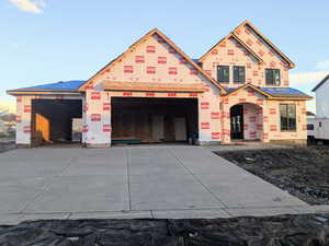 Unfinished property with concrete driveway and a garage