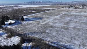 Snowy aerial view featuring a mountain view and a rural view