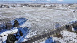 Snowy aerial view with a mountain view and a rural view