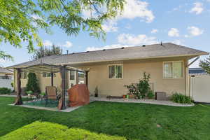Rear view of property featuring a patio area, a shingled roof, and a pergola