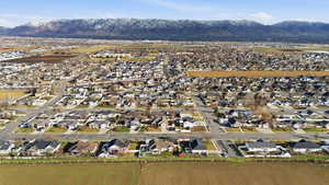 Aerial view of property and surrounding area with nearby suburban area and mountains