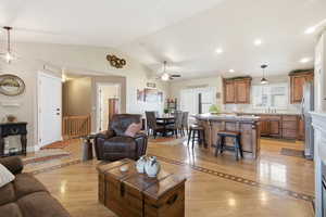 Living room with ceiling fan, lofted ceiling, light wood-type flooring, and recessed lighting