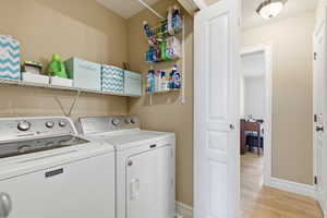 Laundry room with separate washer and dryer and light wood finished floors