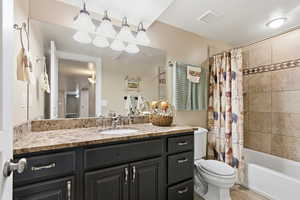 Bathroom with vanity, shower / bath combination with curtain, and light tile patterned flooring