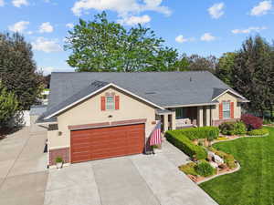 View of front facade featuring a shingled roof, brick siding, concrete driveway, and a garage
