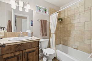 Bathroom with vanity and shower / tub combo with curtain