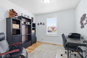 Office space featuring light wood-style flooring and baseboards