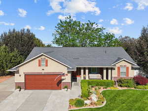 View of front of property with brick siding, a porch, a front yard, and driveway